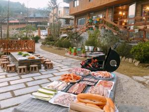 a table with meat and vegetables on a patio at Homestay số 91-Suối Hồ Sa Pa in Sa Pa