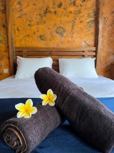 - 2 serviettes sur un lit orné de fleurs dans l'établissement HH Villa, à Rowokele