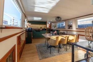cocina y comedor con mesa y sillas en The luxury Boat, en Zwolle