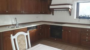 cocina con armarios de madera, fregadero y lavavajillas en Ferienwohnung mit Terrasse, kostenloses WLAN, Parkplatz, en Bad Oeynhausen