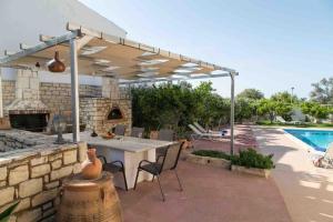 un patio con una mesa y una piscina en Afroditi 4 Villa, en Margarítai