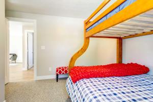 a bedroom with a bunk bed with a red blanket at Mountain-View Cedar City Home with Large Yard! in Cedar City