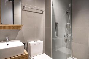 een badkamer met een douche, een toilet en een wastafel bij 3J Living in Binong