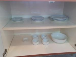 a shelf with plates and bowls on it at Cityview Serviced Apartment & Hotel Ho Chi Minh City in Ho Chi Minh City