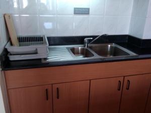 a kitchen counter with a sink and a cutting board at Cityview Serviced Apartment & Hotel Ho Chi Minh City in Ho Chi Minh City
