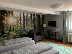 a living room with a wall mural of a forest at Badischer Hof in Bühl