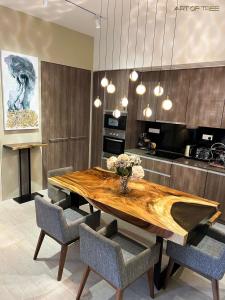 峇都丁宜的住宿－By The Sea Beachfront Designer Suites Penang - Managed by Art of Tree，一间带木桌和椅子的用餐室