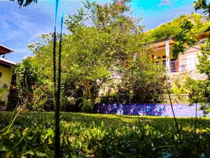 podwórko z domem i trawą i drzewami w obiekcie G-Rima Home Stay w Labuan Bajo