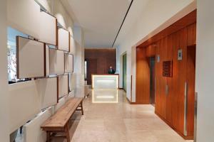 un couloir avec un banc et des murs en bois dans l'établissement COMO Metropolitan London, à Londres