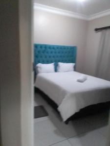 um quarto com uma cama com uma cabeceira azul em Golf view place em Empangeni