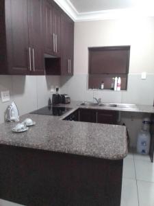 a kitchen with brown cabinets and a granite counter top at Golf view place in Empangeni