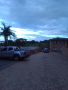a truck parked in a parking lot with a palm tree at Golf view place in Empangeni
