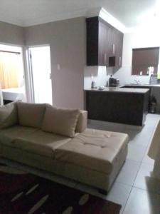 a living room with a couch and a kitchen at Golf view place in Empangeni
