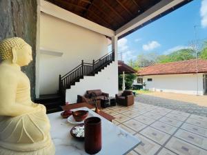 a statue sitting on a table in front of a house at Yala Visit Villa in Tissamaharama