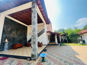 a building with a porch with a blue umbrella outside at Yala Visit Villa in Tissamaharama