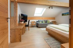 ein Schlafzimmer mit 2 Betten und einem Sofa in einem Zimmer in der Unterkunft Pension Bernhardhof in Otterfing