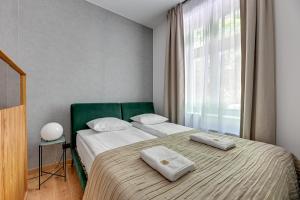 sypialnia z 2 łóżkami i oknem w obiekcie Royal Apartments - Winieckiego w mieście Sopot