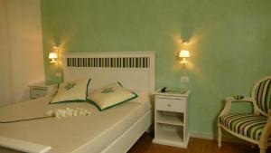 1 dormitorio con 1 cama con 2 almohadas y 1 silla en Bed & Breakfast Venezia en Marina di Carrara