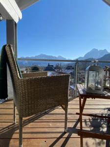 een rieten stoel op een terras met een tafel bij Penthouse Bargholz in Füssen