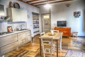 uma cozinha e sala de jantar com uma mesa e um lavatório em La Corte di Grazia_IUN P2039/40 em Nuoro