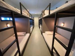 a row of bunk beds in a room at The Train Hotel Hatyai in Hat Yai