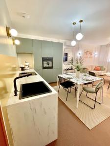 a kitchen and a living room with a table at Les 3 arches - Grenoble in Grenoble