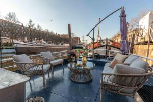 Un balcón con sillas, mesas y un barco. en The luxury Boat, en Zwolle