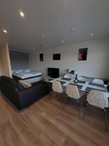a living room with a couch and a table and a bed at Topelius Park Apartment in Uusikaarlepyy