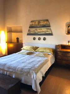 1 dormitorio con 1 cama y una pintura en la pared en Borgo dei Conti Campello, en Campello sul Clitunno