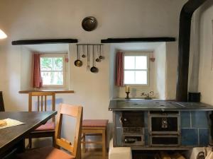 eine Küche mit einem alten Herd und einem Esstisch in der Unterkunft Ferienhaus Lindaubachgütl in Fieberbrunn