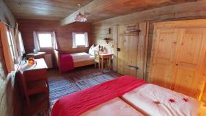 ein Schlafzimmer mit einem Bett in einer Holzhütte in der Unterkunft Ferienhaus Lindaubachgütl in Fieberbrunn