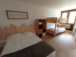 1 dormitorio con 1 cama, 1 litera y 1 silla en Superbe 3 pieces vue panoramique pied des pistes en La Mongie