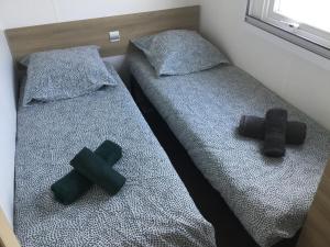 two beds with crosses on them in a room at Mobilhome2frejus in Fréjus