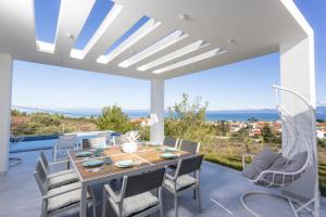 a dining room with a table and chairs on a patio at Panoramic Villa #1 in Hanioti
