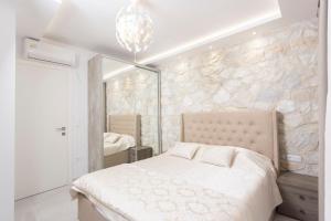 a bedroom with a bed and a stone wall at Panoramic Villa #1 in Hanioti