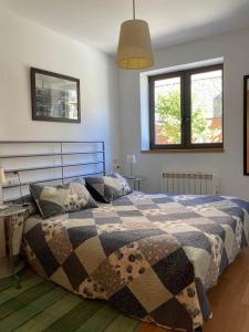 バレンシア・デ・アヌーにあるApartamentos Bonaigua TGのベッドルーム1室(毛布、窓2つ付)