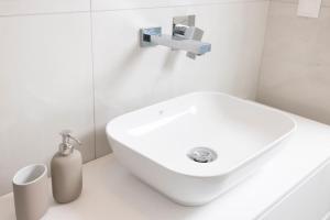 a bathroom with a white sink in a white room at Panoramic Villa #1 in Hanioti +16 photos