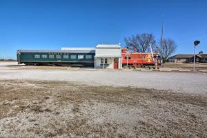 einem roten Zug neben einem Gebäude in der Unterkunft Unique Joplin Gem Converted Train Car Studio in Joplin