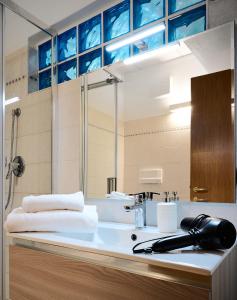 W łazience znajduje się umywalka i prysznic. w obiekcie Domus Dea Città Alta w Bergamo