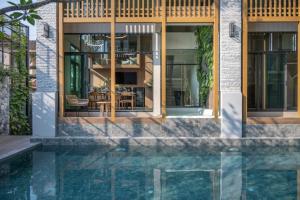 a house with a pool in front of it at SHAN Villas Sukhumvit in Bangkok