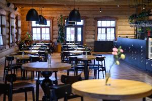 restauracja z drewnianymi stołami, krzesłami i oknami w obiekcie Hotel Picaro Stok w Łagowie