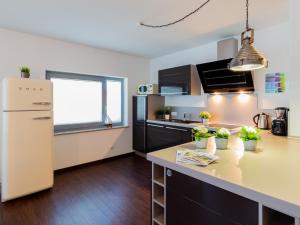 Una cocina con un refrigerador blanco y una encimera. en Ferienwohnung Zeitlos mit Sund- und Seeblick, en Altefähr