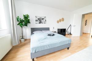 a white bedroom with a bed in a room at Full House Apartment MCity L10 in Magdeburg