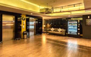 a large room with a couch and a drink machine at Yellow Bee Tangerang in Tangerang