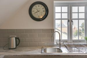 a clock on the wall above a kitchen sink at Towerview Apartments Braintree in Braintree