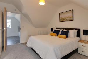 ein Schlafzimmer mit einem großen weißen Bett mit orangefarbenen Kissen in der Unterkunft Towerview Apartments Braintree in Braintree