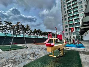 a playground with a slide and a swing at The D Carlton HomeStay 2BR in Masai