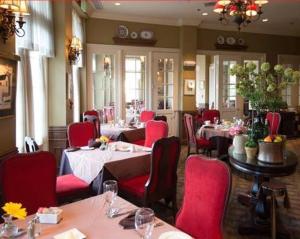 een restaurant met tafels en rode stoelen en een tafeltennistafel bij River Inn of Harbor Town in Memphis
