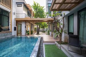 a swimming pool in the backyard of a house at SHAN Villas Sukhumvit ฌานวิลล่า สุขุมวิท in Bangkok