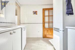 eine Küche mit weißen Schränken und einem Kühlschrank in der Unterkunft Beferent Sol y Mar Muchavista in El Campello